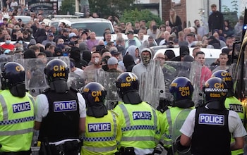 Riot police hold back protesters
