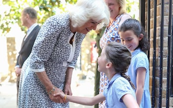 Queen Camilla is greeted by a schoolgirl from Christ Church CofE primary school