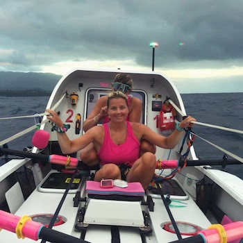 Two of the women pose on the boat, at sea