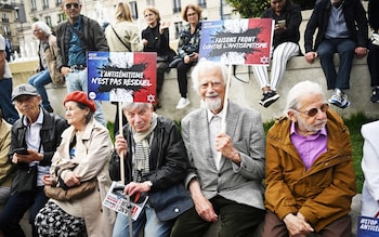 People attend a demo<em></em>nstration against anti-Semitism in front of Paris City Hall holding cards with slogans that read 'Anti-Semitism is not residual'