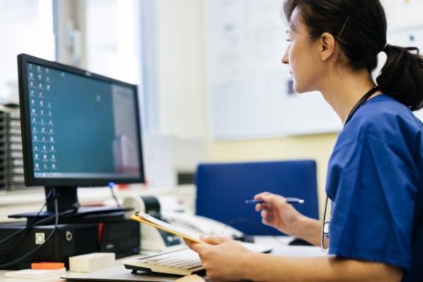 Mature female doctor sitting in her office and working on a computer