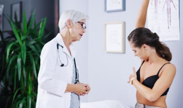 A woman havin<em></em>g her breast examined by a female doctor as Doctors warn over 'unknown' breast cancer symptoms