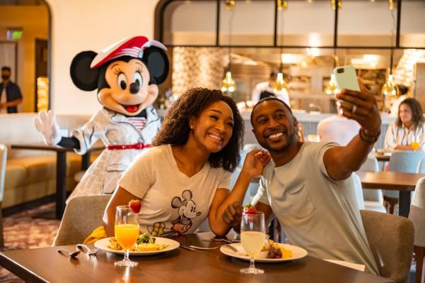Couple dining at Dinsey take a selfie with Minnie Mouse