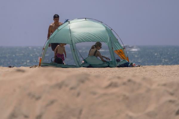 California beach goers on Friday ahead of tropical storm on the way. A family hangs out around a tent on the beach.