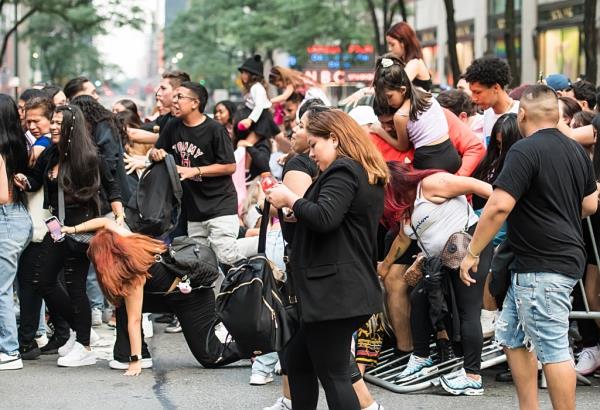 Fans crash the barricade to get closer to the stage area.