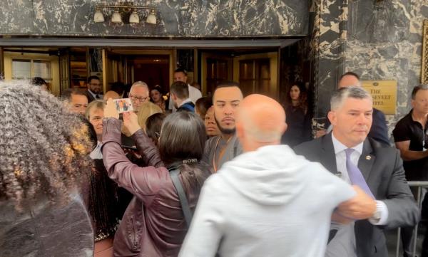 At one point during the press conference, a security guard grabbed a yelling male protestor and shoved him behind a barricade.