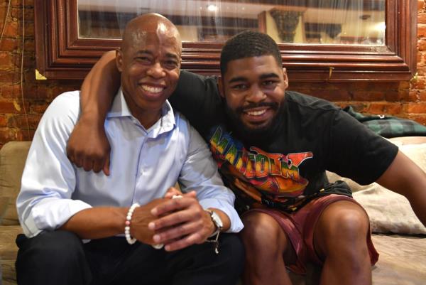 Jordan Coleman has his arm around Mayor Eric Adams, his father as the two smile.