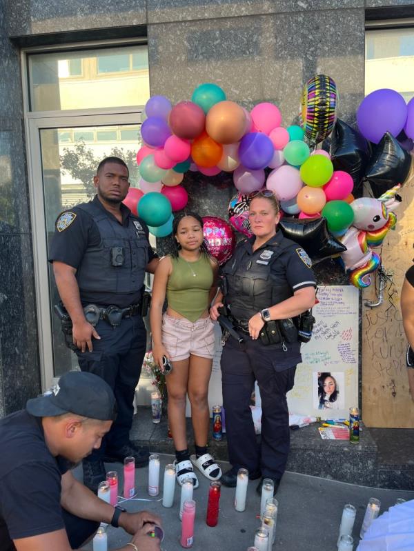 Laurel, daughter of Stephanie Qui?ónes, who died at the Dolaj Astoria nightclub after nobody called 911, standing oututside the Dolan nightclub my a makeshift memorial with NYPD officers.