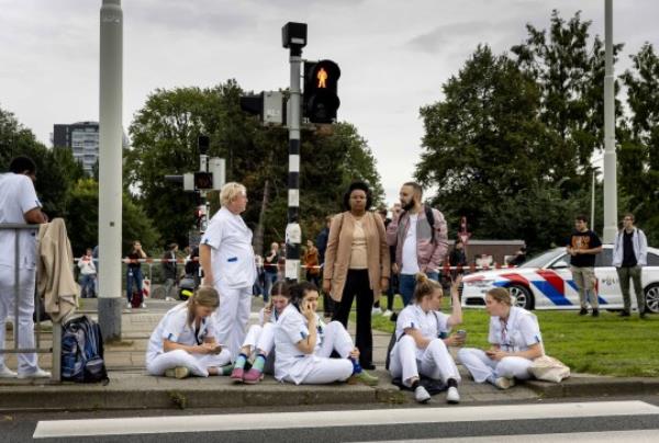 epa10887899 Medical staff wait outside the Erasmus MC Rotterdam hospital on Rochussenstraat, which has been cordo<em></em>ned off after two shooting incidents in Rotterdam, Netherlands, 28 September 2023. An unknown person wearing combat clothing shot at people first in an apartment and after in the hospital, the police announced. EPA/SEM VAN DER WAL