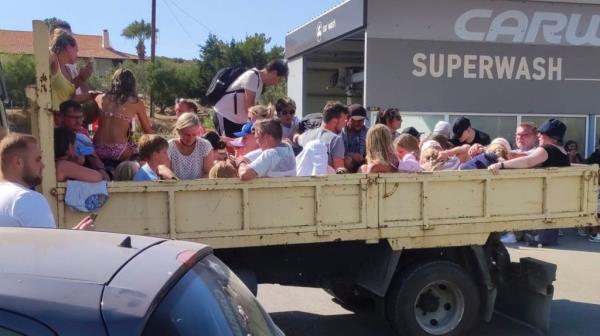 Tourists evacuated in Rhodes, Greece on back of truck
