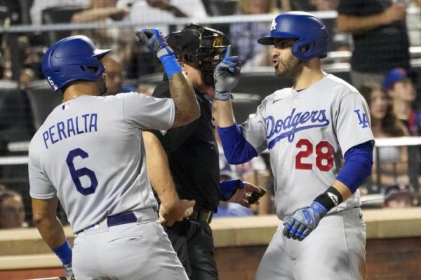 Dodgers' Bobby Miller hands the ball to manager Dave Roberts in front of catcher Will Smith.