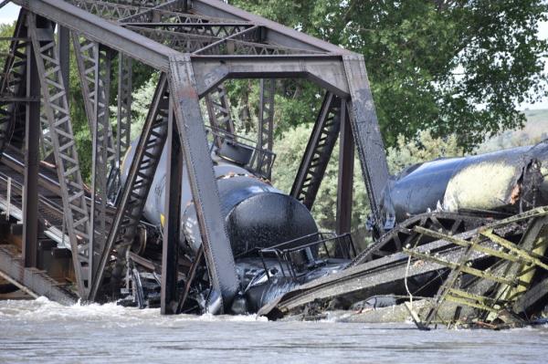 Several train cars are immersed in the Yellowstone River after a bridge collapse near Columbus, Mont., Saturday, June 24, 2023.