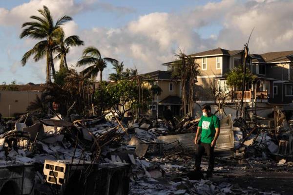 Volunteer is pictured in midst of devastated homes on Maui.