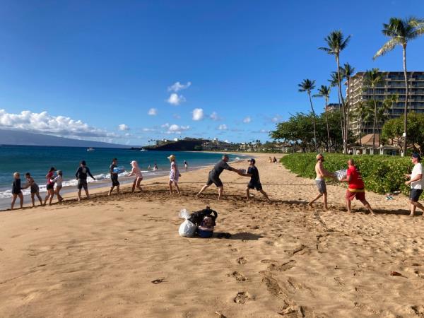 Volunteers are pictured on Maui delivering supplies to the island in a line from the ocean to the shore.  
