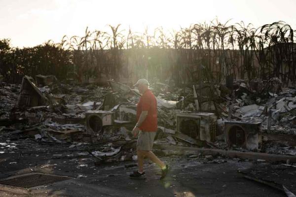 A man walks through rubble in Lahaina 