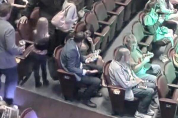 The pregnant woman went to ask an usher if there were any seats available away from the troublemakers. 
