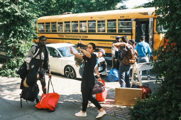 A social worker from the facility tries to block photographs of the arrival.