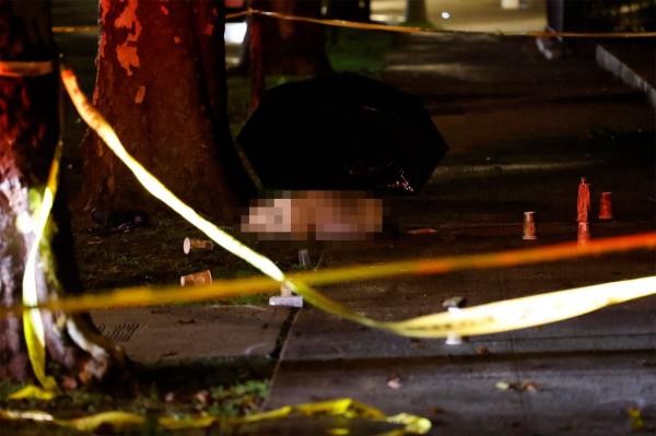 Shooting scene on sidewalk at night behind caution tape