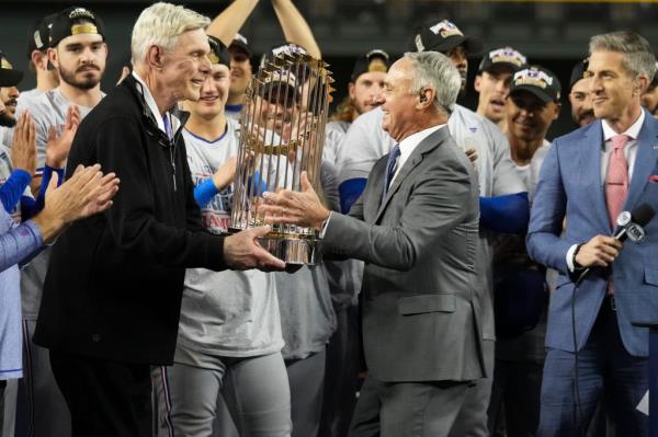 Rob Manfred awards the Commissioner's Trophy on the field to the Texas Rangers Owner Ray Davis.