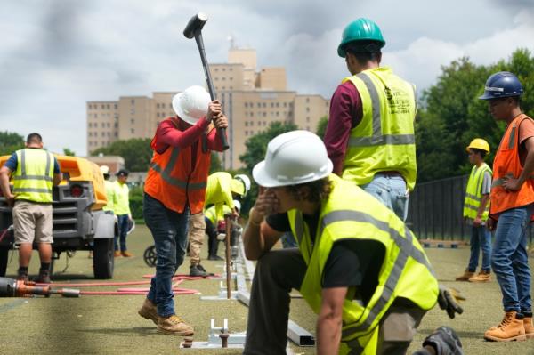 Workers putting up the ba<em></em>ses for tents that will shelter migrants on Randalls Island on August 8, 2023. 