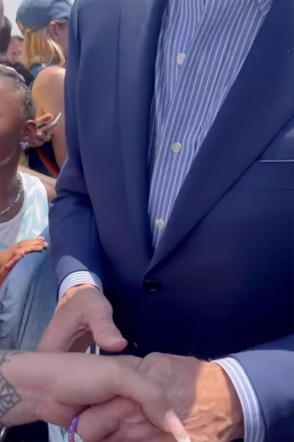 Before pulling down her top, the activist was seen shaking hands with Biden.