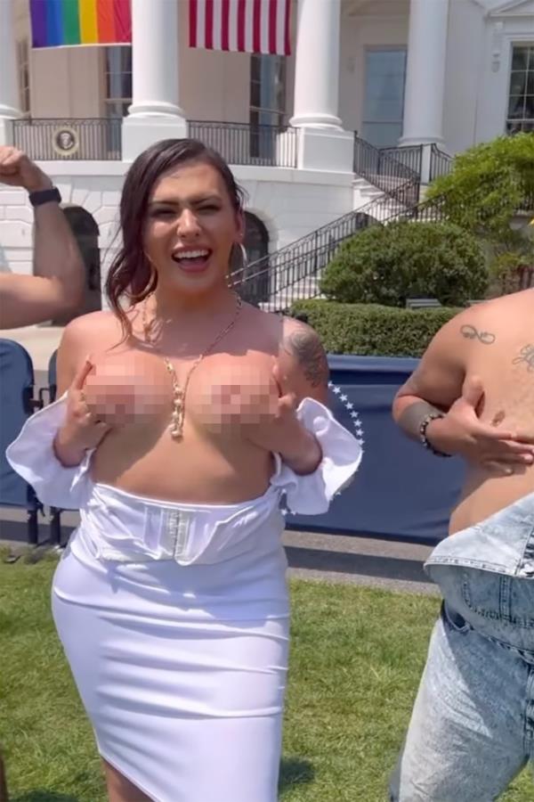 Rose Montoya, a transgender woman, is seen with her top down, covering her breast with her hands in front of the White House.
