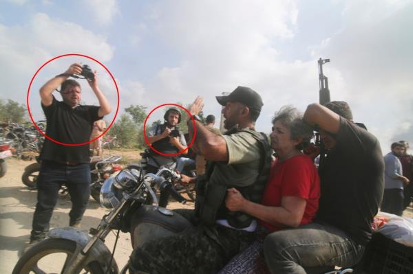 Palestinians transport a captured Israeli civilian, center, from Kibbutz Kfar Azza into the Gaza Strip on Saturday, Oct. 7, 2023. 
