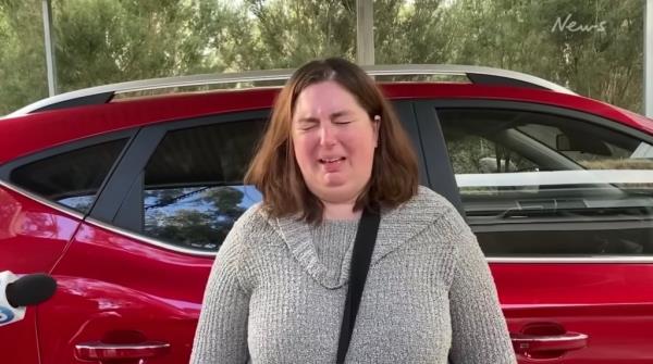 Photo of a woman crying with short brown hair. 