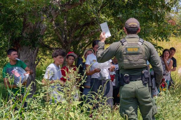 A border patrol agent talking to immigrants in Eagle Pass, Texas. 
