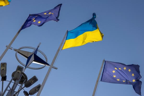 Two Ukrainian and two European Unio<em></em>n flags fly atop flagpoles.