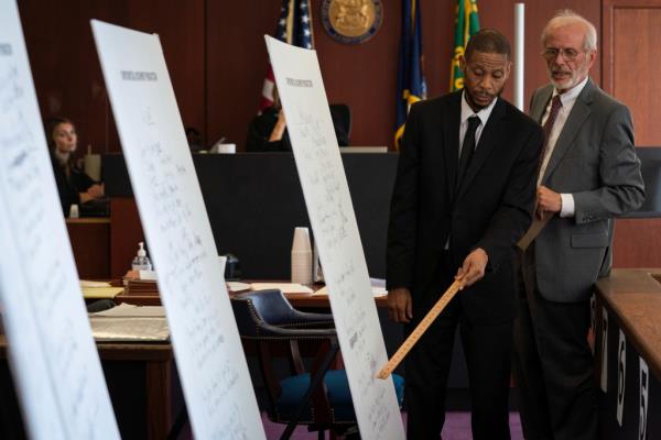 Lawyer pointing to the blown up photos of the 2014 will.