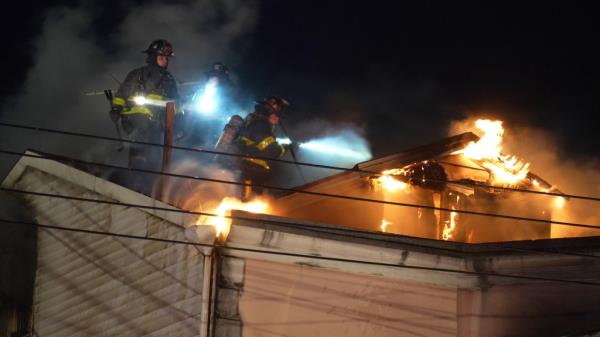 A group of firefighters on a roof, respo<em></em>nding to a house fire in Dyker Heights, reportedly started by a squatter named Cheng Chen.