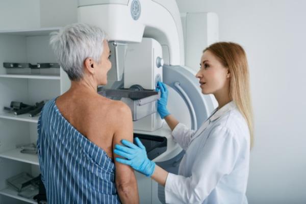Senior woman havin<em></em>g mammography scan at hospital with medical technician. Mammography procedure, breast cancer prevention