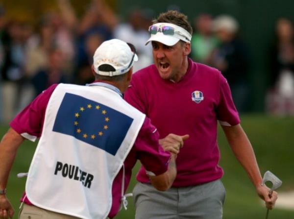 an Poulter of Europe celebrates with his caddie Terry Mundy after making birdie on the 16th green during day two of the Afternoon Four-Ball Matches for The 39th Ryder Cup at Medinah Country Club.