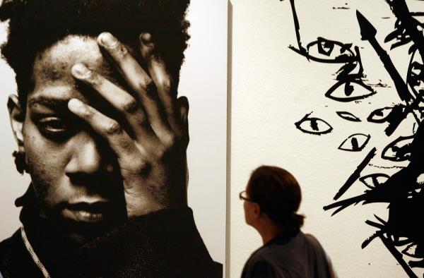 A woman looks at a work by late Haitian-American Jean-Michel Basquiat at an exhibition in Milan September 19, 2006