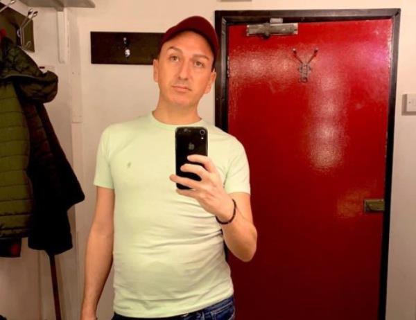 Jason Reid in mirror selfie. He is a caucasian male wearing a red cap and white t-shirt