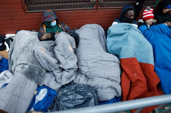 Migrants sleeping out in the cold are waiting to go into a shuttered Catholic School on the Lower East Side.