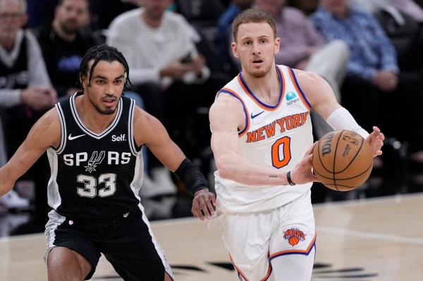 New York Knicks guard Jalen Brunson (11) drives to the basket while defended by San Anto<em></em>nio Spurs guard Tre Jones