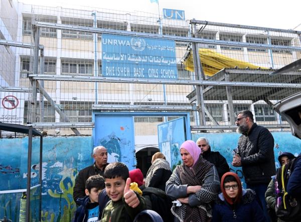 Palestinian refugees boys stand at the entrance to the UN Relief and Works Agency for Palestinian refugees (UNWRA) school in the Dheisheh Refugee Camp near Bethlehem, West Bank, on Tuesday, January 30, 2024.