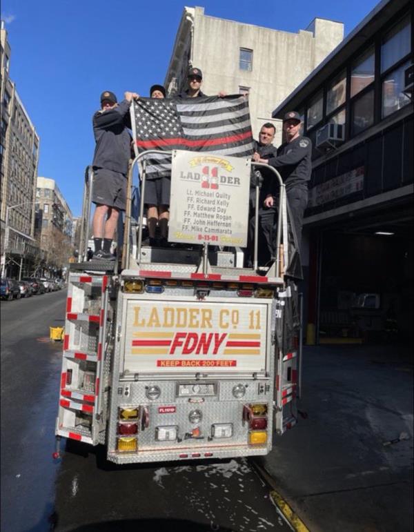Firefighters at Ladder 11 holding up the 