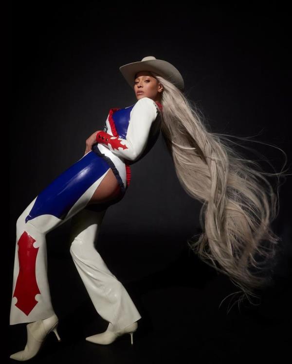 Beyoncé posing in a cowboy hat and red, wite a blue cowgirl-stye suit with rear-exposing cutouts