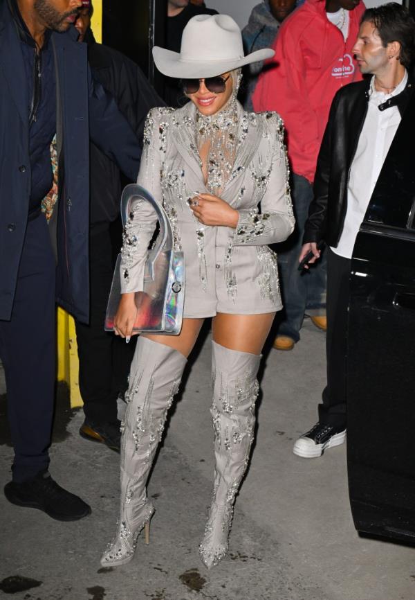 Beyoncé at the Luar fashion show in New York, wearing gray boots and a jacket adorned with crystals, and a cowboy hat