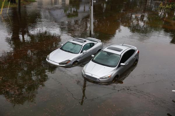 Cars sit in flood waters from Hurricane Idalia after it passed offshore in Tarpon Springs, Florida. 