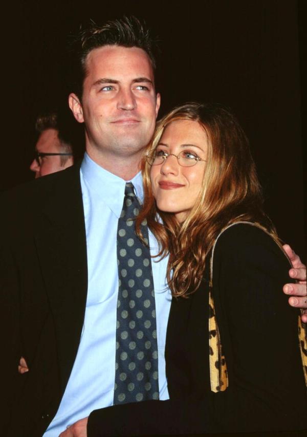 Matthew Perry smiling with his arm around Jennifer Aniston. 