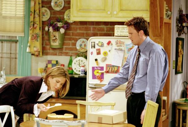 Rachel and Chandler bent over a table on 