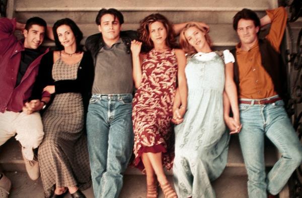 David Schwimmer, Courteney Cox, Matt LeBlanc, Jennifer Aniston, Lisa Kudrow, Matthew Perry lying down in a line, smiling. 