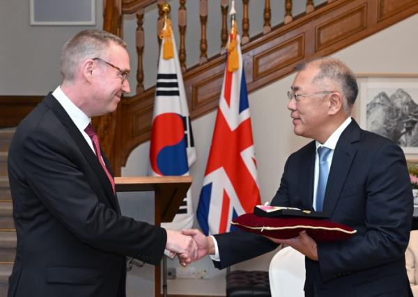 Hyundai　Motor　Chairman　Chung　Euisun　(right)　shakes　hands　with　British　Amb.　Colin　Crooks　after　he　won　the　CBE　medal　from　King　Charles　III