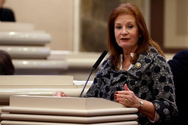 State Rep. Terri Collins speaking into a microphone on the House floor during debate over SB159 bill (IVF Fertility Bill) in Montgomery, Ala.