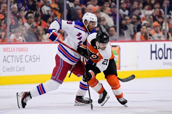 Philadelphia Flyers' Scott Laughton (21) and New York Rangers' K'Andre Miller (79) battle for the puck during the second period