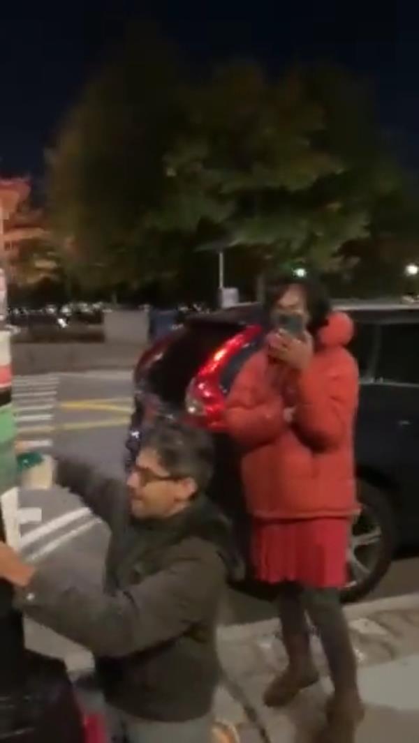 A screengrab from the video shows Gupta plastering the signs on a lamppost.